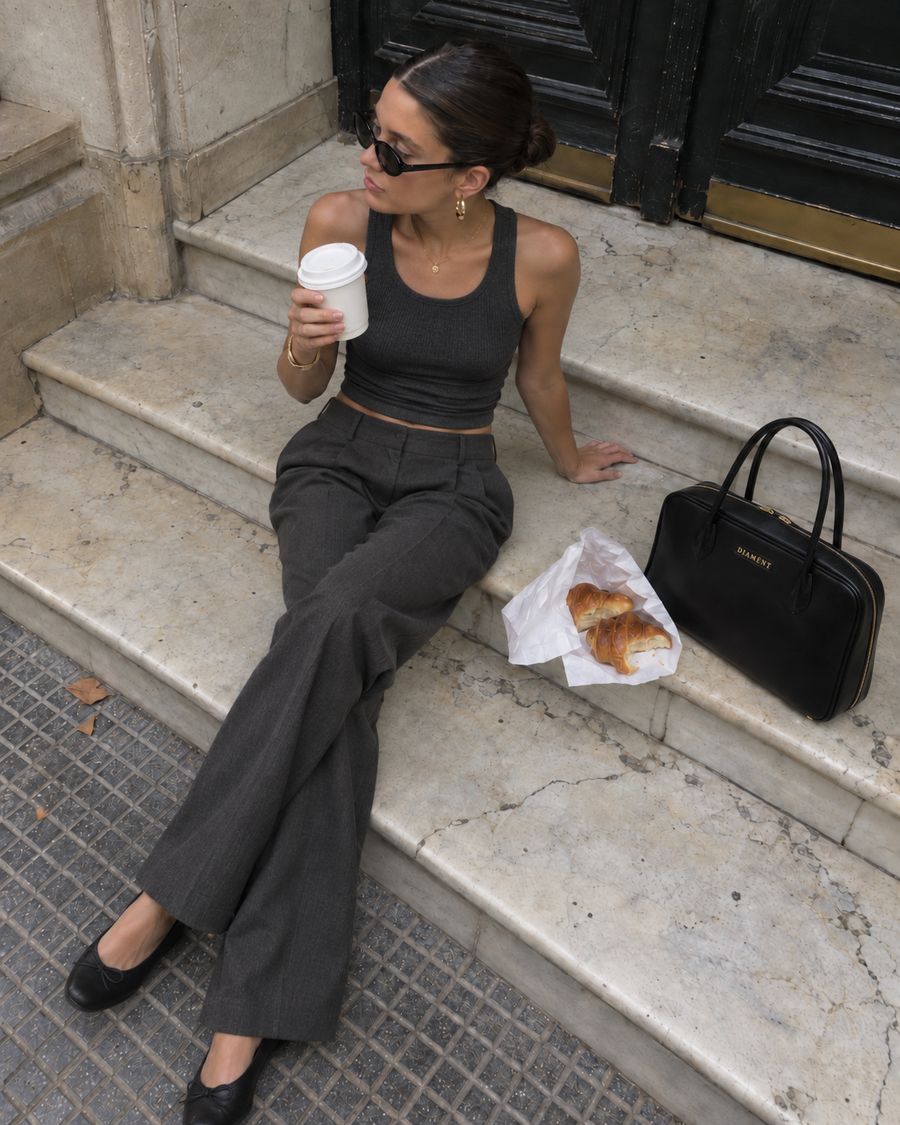 Gilly apoyada en una escalera de mármol, junto a un café y medialunas